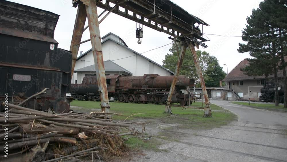 Handheld view of abandoned rail station museum and small crane