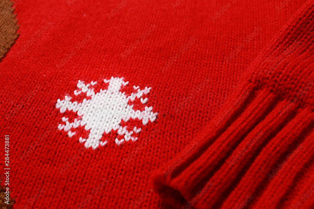 Warm red Christmas sweater with snowflake as background, closeup view