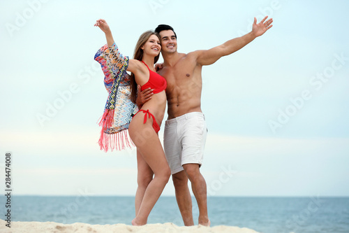 Happy young couple spending time together on sea beach