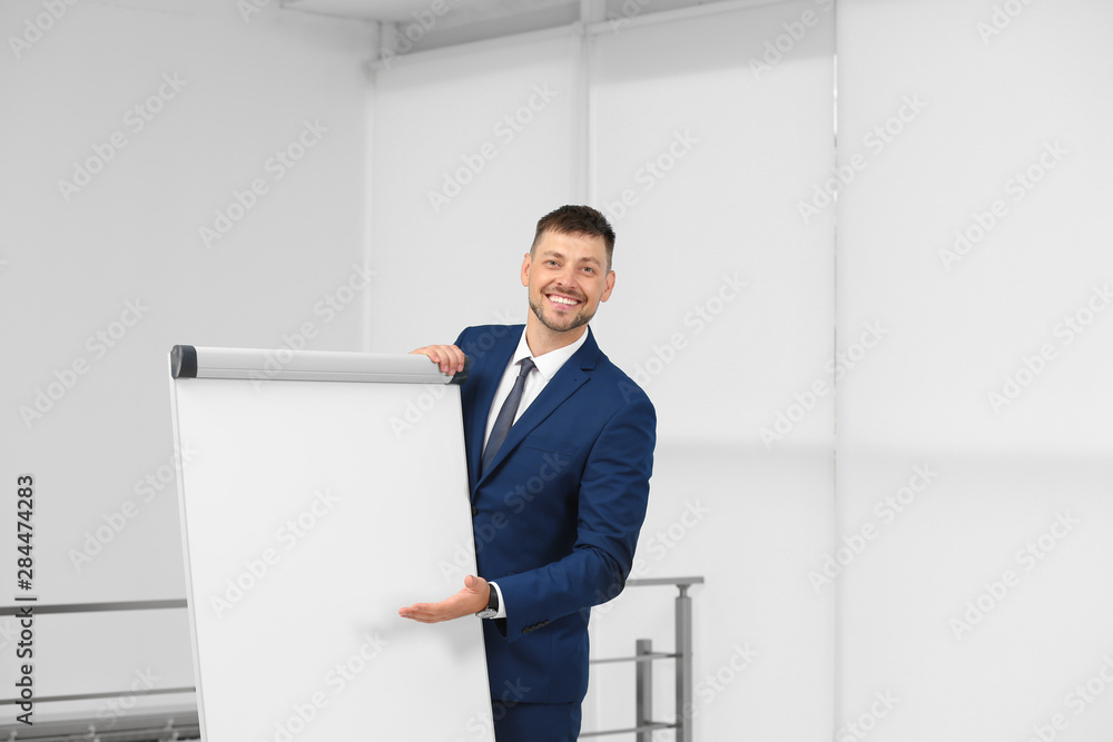 Professional business trainer near flip chart board indoors. Space for text Professional business trainer near flip chart board indoors. Space for text