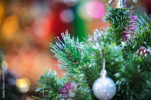 Decorations on christmas tree at night with bokeh on background, soft focus