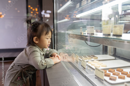 Asian cute little girl looking excited in bakery counter. photo