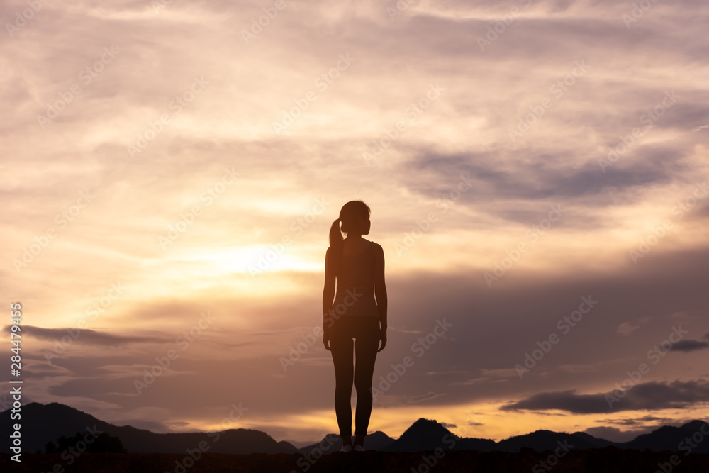 silhouette lonely girl standing on top of mountain