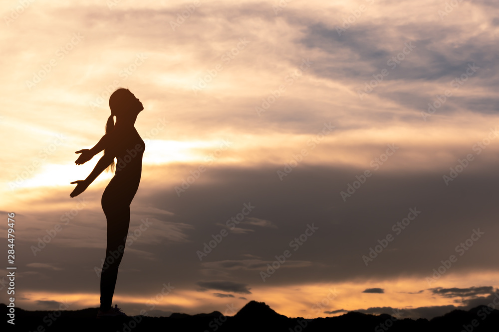 silhouette girl standing and relaxing on top of mountain