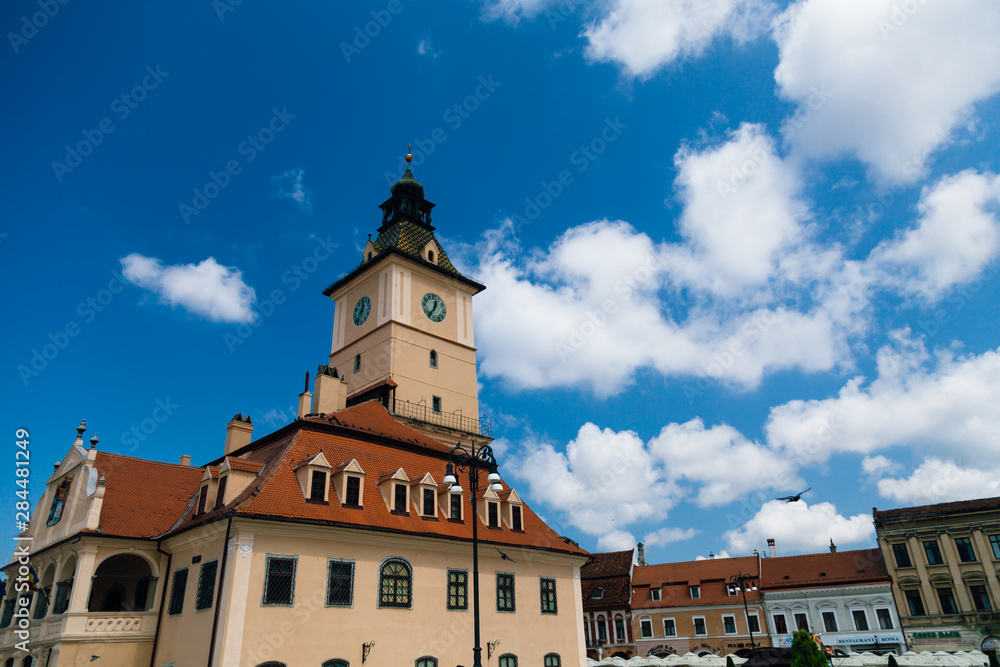 The old Town Square of Brasov (Piata Sfatului). The famous City Hall building with the clock tower seen in the background.