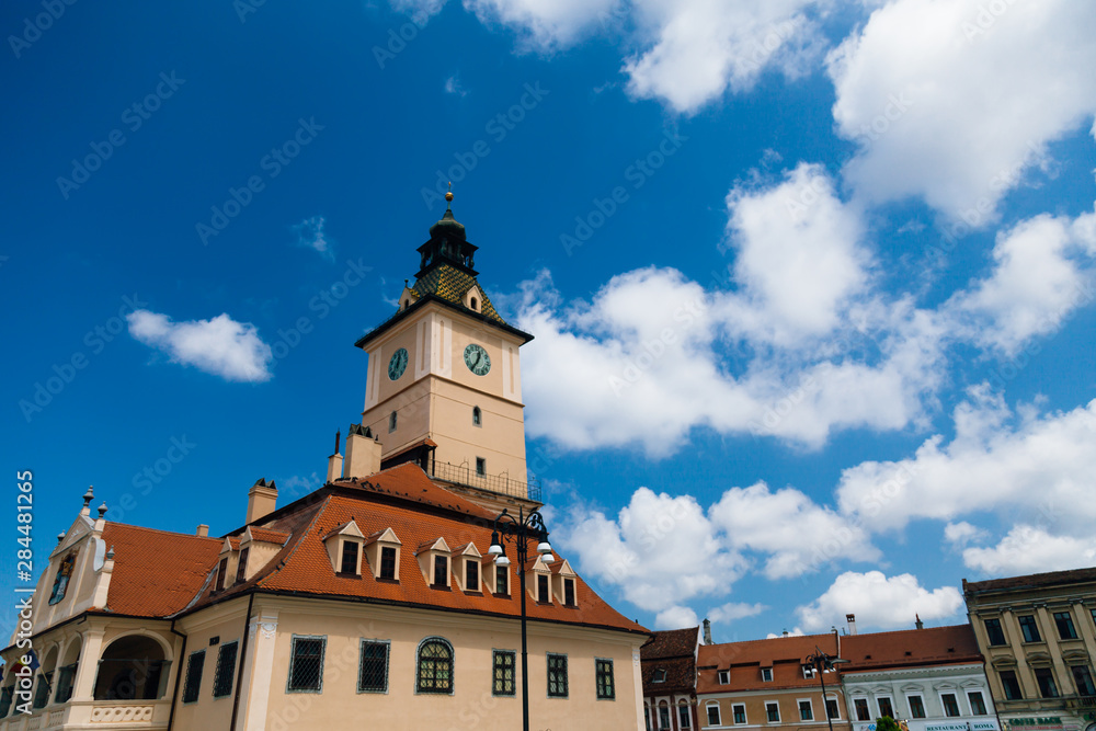 Fototapeta premium The old Town Square of Brasov (Piata Sfatului). The famous City Hall building with the clock tower seen in the background.
