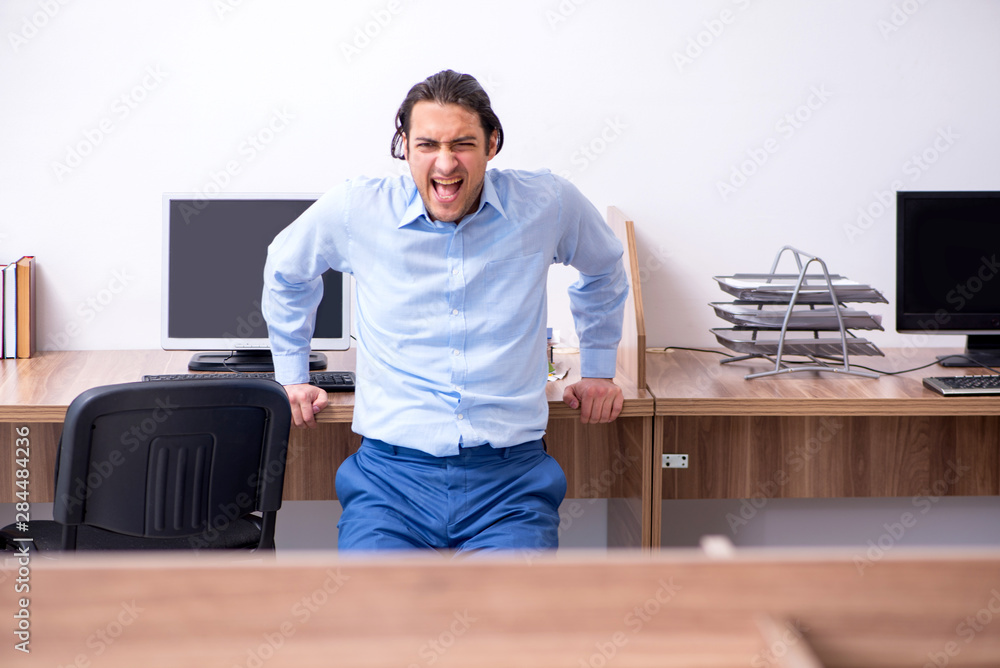 Young handsome businessman doing exercises at workplace Young handsome businessman doing exercises at workplace