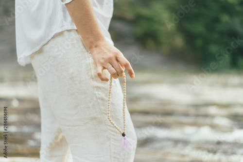 peaceful woman is making mantra meditation near river