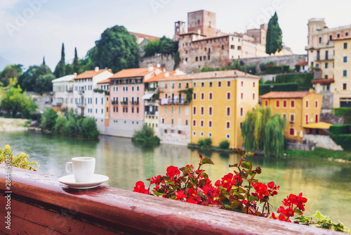 Cup of coffee on balcony with beautiful italy town at background, Bassano del Grappa, Veneto region, Italy, Vacations in Italy concept photo