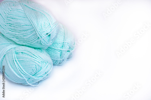 Three skeins of yarn for knitting mint color on a white background, isolation, copy space.