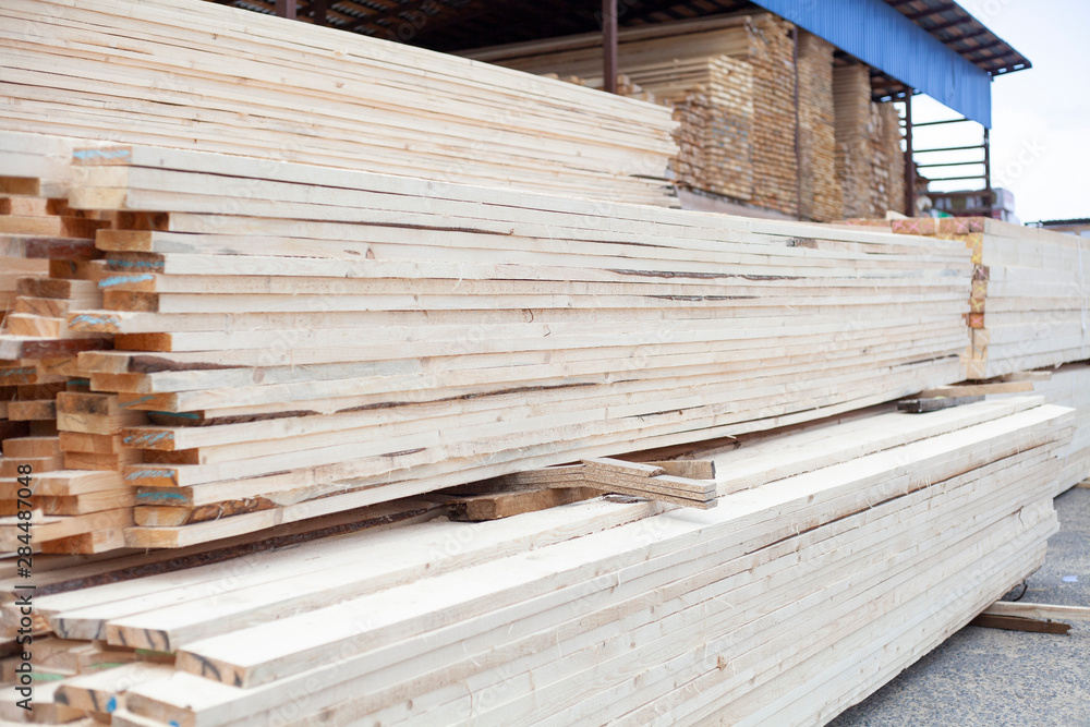 Boards in stock. Building materials from wood. The result of logging under the board. Beams for building a house. Boards in stock. Building materials from wood. The result of logging under the board. Beams for building a house.