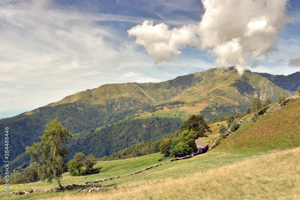 Fototapeta premium Paesaggio alpino, con il cielo blu e le nuvole bianche.