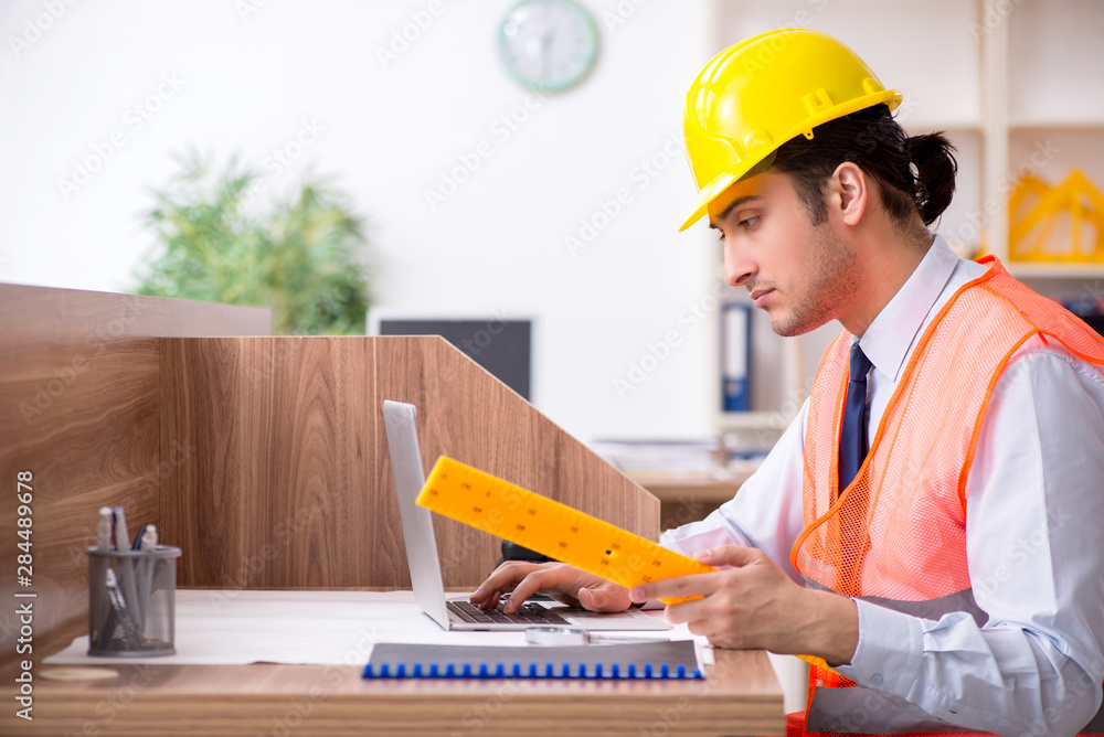 Young male architect working in the office Young male architect working in the office