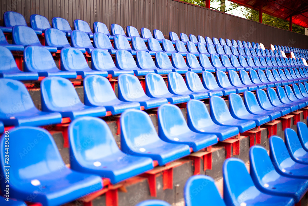 Fototapeta premium Rows of seats in the stadium. Blue seats in the sports arena. A place to watch sports.