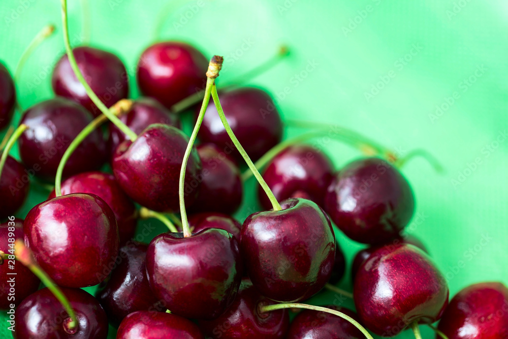 Fresh and ripe cherries on green background Fresh and ripe cherries on green background