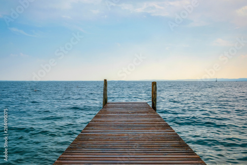 Landscape with the image of a pier on Garda lake in Italy
