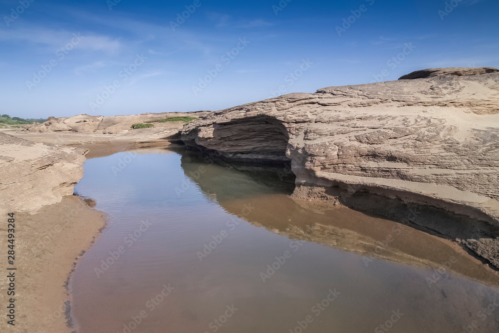 view of Nature rock and water in Mekong river with blue sky background, Sam Phan Bok known as The Grand Canyon of Thailand, attraction in Ubon Ratchathani, Thailand.