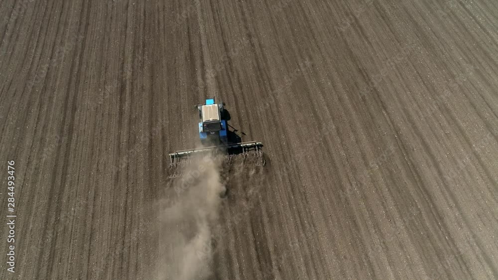 Aerial shot of tractor preparing land with seedbed cultivator. UHD, 4K Aerial shot of tractor preparing land with seedbed cultivator. UHD, 4K