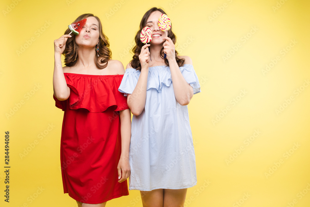 Horizontal portrait of two cheerful young women having fun together on background. Horizontal portrait of two cheerful young women having fun together on background.
