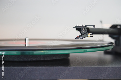 Recordplayer with stylus floating above a record photo