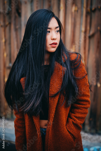 beautiful young serious asian woman with black hair and orange kashmere outdoor