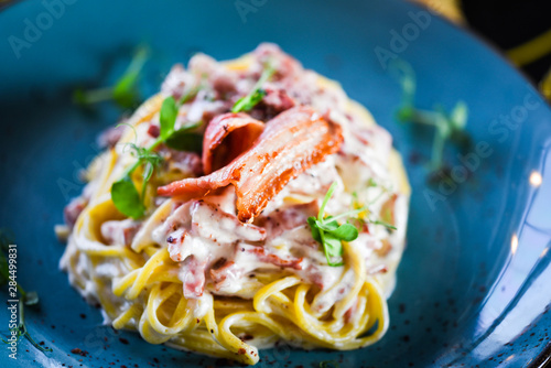 fresh italian spaghetti carbonara with tasty ingredients - cream, egg, bacon