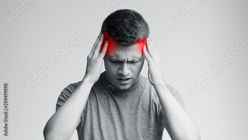 Young man with strong headache, monochrome photo photo