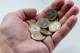 Männerhand eines Europäers hält EURO-Münzen zur Bezahlung mit Bargeld, Schuldenbegleichung oder zum Ausdruck von Armut und Reichtum