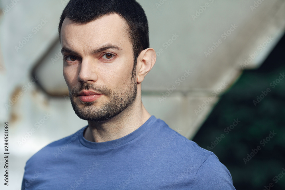 Bearded middle-aged charismatic man posing over metal construction. Text-space. Grunge style. Close up outdoor shot Bearded middle-aged charismatic man posing over metal construction. Text-space. Grunge style. Close up outdoor shot