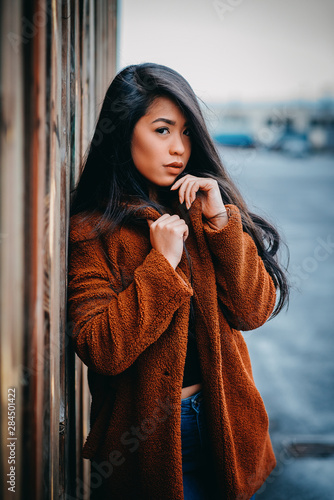 beautiful young serious asian woman with black hair and orange kashmere outdoor photo