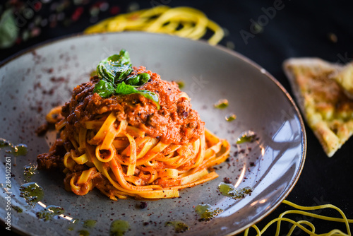 delicious italian spaghetti bolognese with minced beef sauce, tomatoes, carrots & fresh basil  photo
