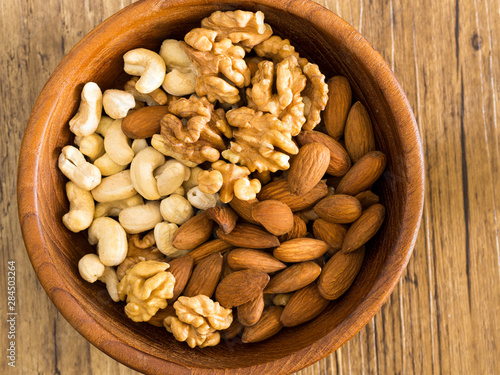 walnuts, cashews and almonds in a wooden plate. healthy foods