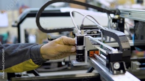 engineer removing nozzle from machine at surface mount Technology(SMT) for maintenance and clearing, place to electronic equipment, blur background