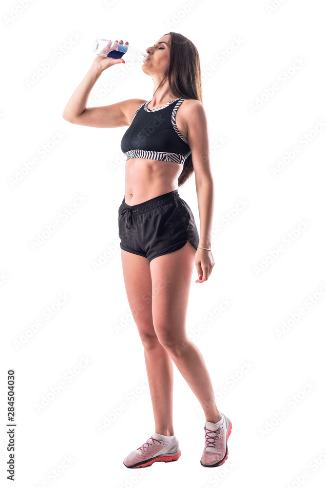 Profile view of tired young woman refreshing and drinking water after exercise. Full body isolated on white background. Profile view of tired young woman refreshing and drinking water after exercise. Full body isolated on white background.