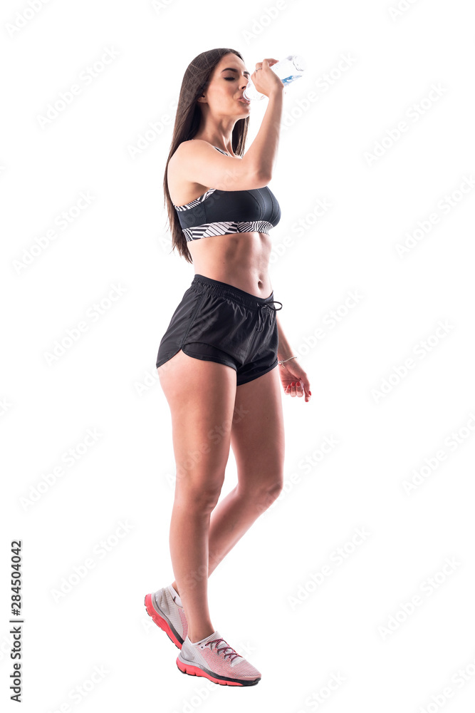 Side view of exhausted woman runner taking break drinking water with closed eyes. Full body isolated on white background. Side view of exhausted woman runner taking break drinking water with closed eyes. Full body isolated on white background.