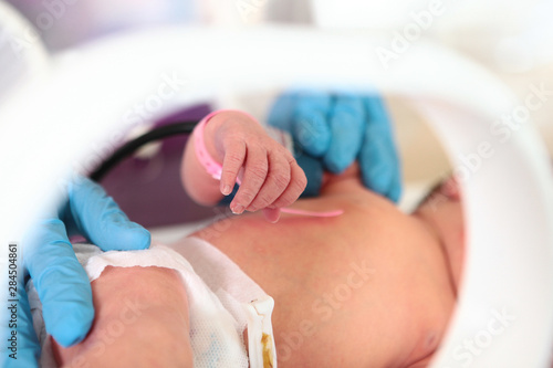 Handle of a newborn baby in intensive care unit in a medical incubator. Macro photo of the hands of a doctor and the handles of a child. Newborn rescue concept. The work of resuscitation doctors.