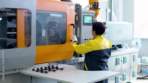 Operator takes out the plastic product from the forging apparatus