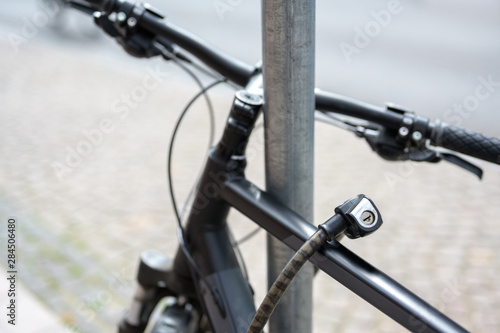 bicycle detail with a lock chained to a metal pole, theft protection concept