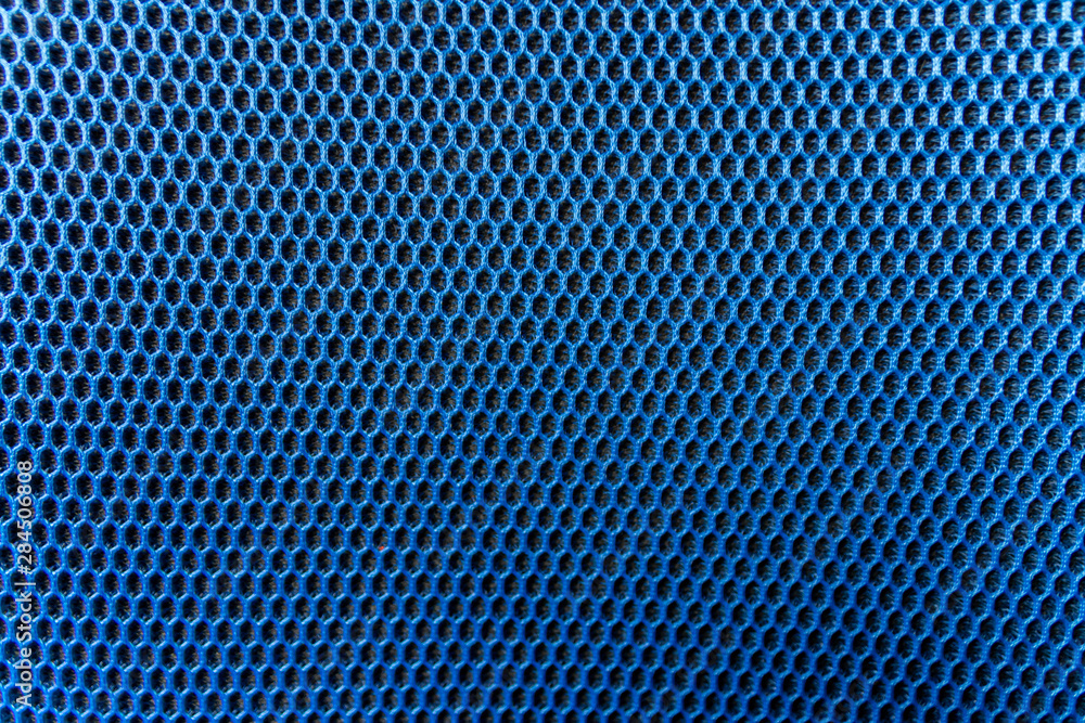 Blaues Gewebe mit elastischer und gleichmäßiger Wabenstruktur und schwarzem Polsteruntergrund als schöner Hintergrund mit copy space Blaues Gewebe mit elastischer und gleichmäßiger Wabenstruktur und schwarzem Polsteruntergrund als schöner Hintergrund mit copy space