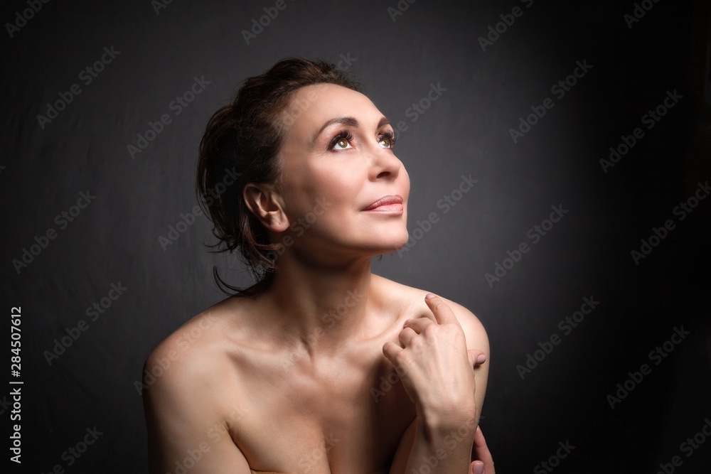 portrait of a sensual fifty year old woman on grey studio background portrait of a sensual fifty year old woman on grey studio background