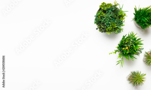 Artificial plants in various pots on white background
