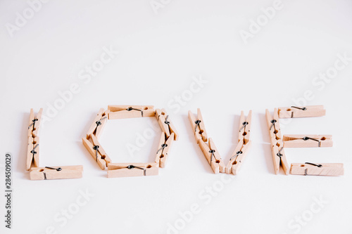 Wooden clothespins on a white background with the inscription the word love. View from above