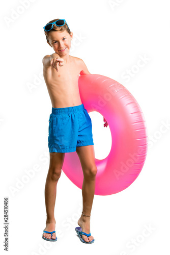 A full-length shot of Child on summer vacation points finger at you on isolated white background