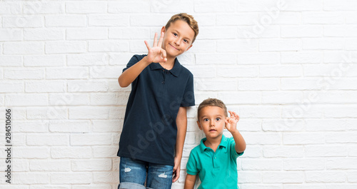 Two little brothers showing an ok sign