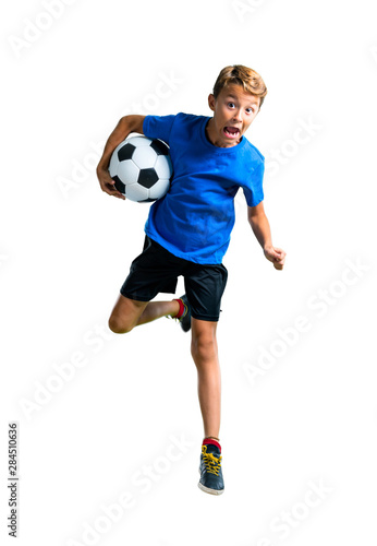 A full-length shot of Boy playing soccer and jumping on isolated white background © luismolinero