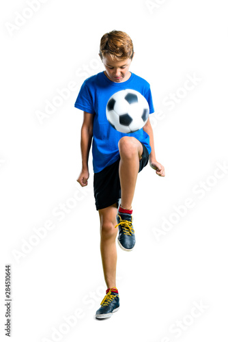 A full-length shot of Boy playing soccer on isolated white background © luismolinero