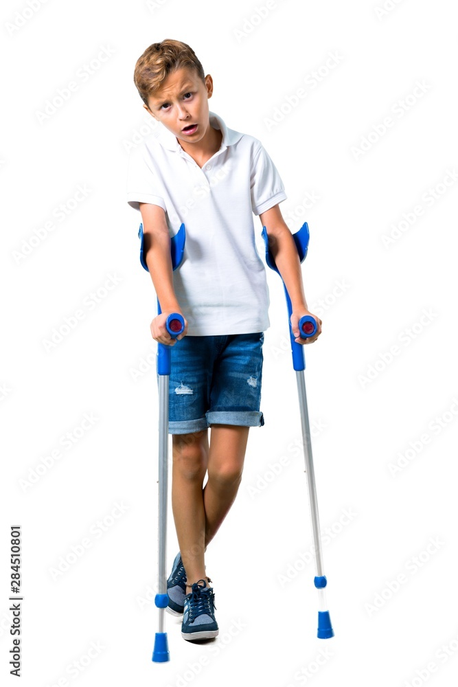 Little kid with crutches on isolated white background Little kid with crutches on isolated white background
