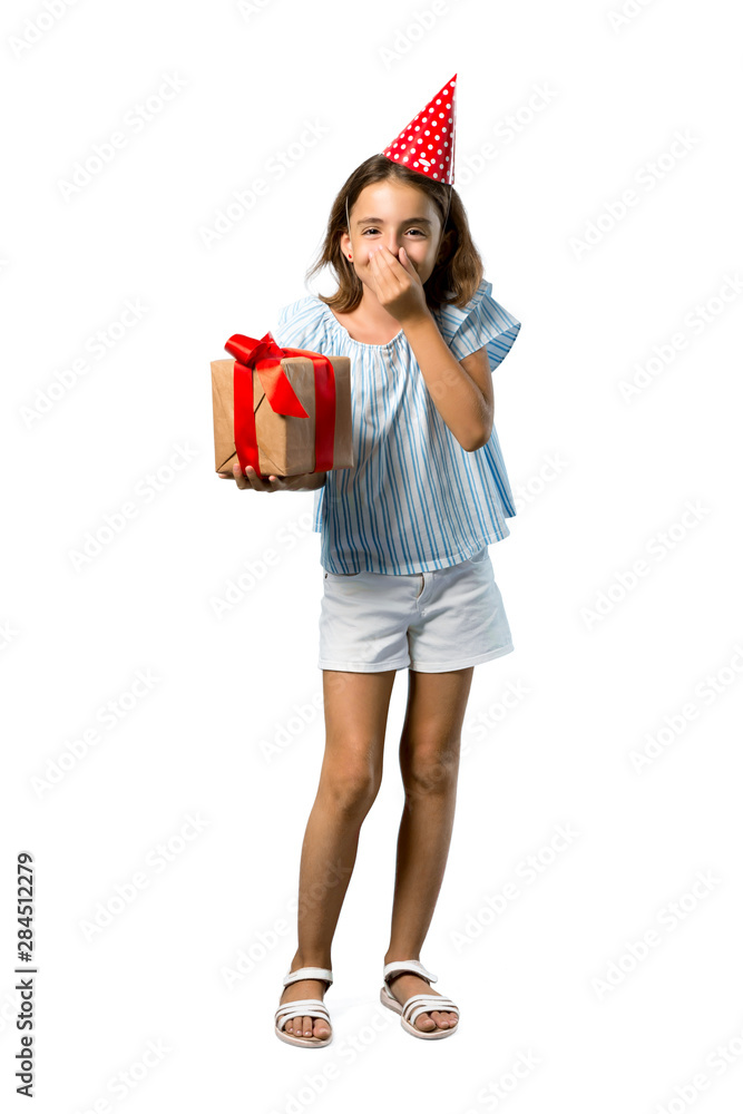 A full-length shot of a Little girl at a birthday party holding a gift laughing on isolated white background A full-length shot of a Little girl at a birthday party holding a gift laughing on isolated white background
