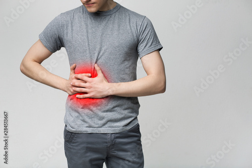 Man in pain holding his stomach on right side photo
