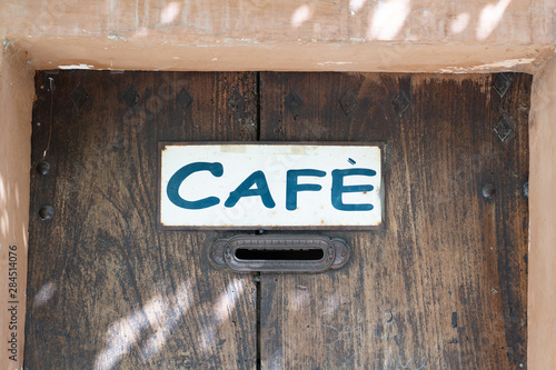 cafe sign on wooden ancient door in old facade in europe